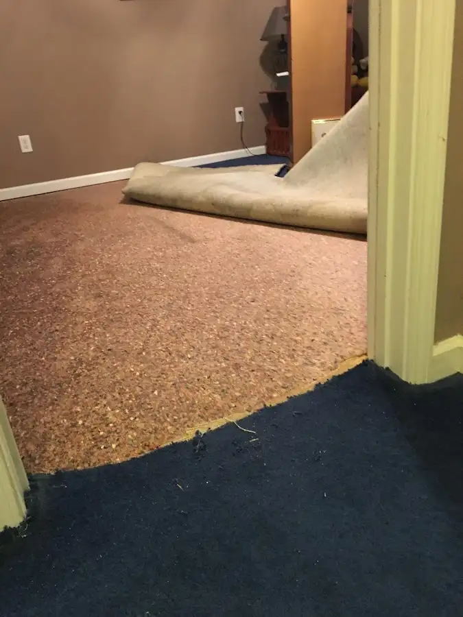 Carpet pad removal revealing water damage during Water Mitigation Services in Perth Amboy